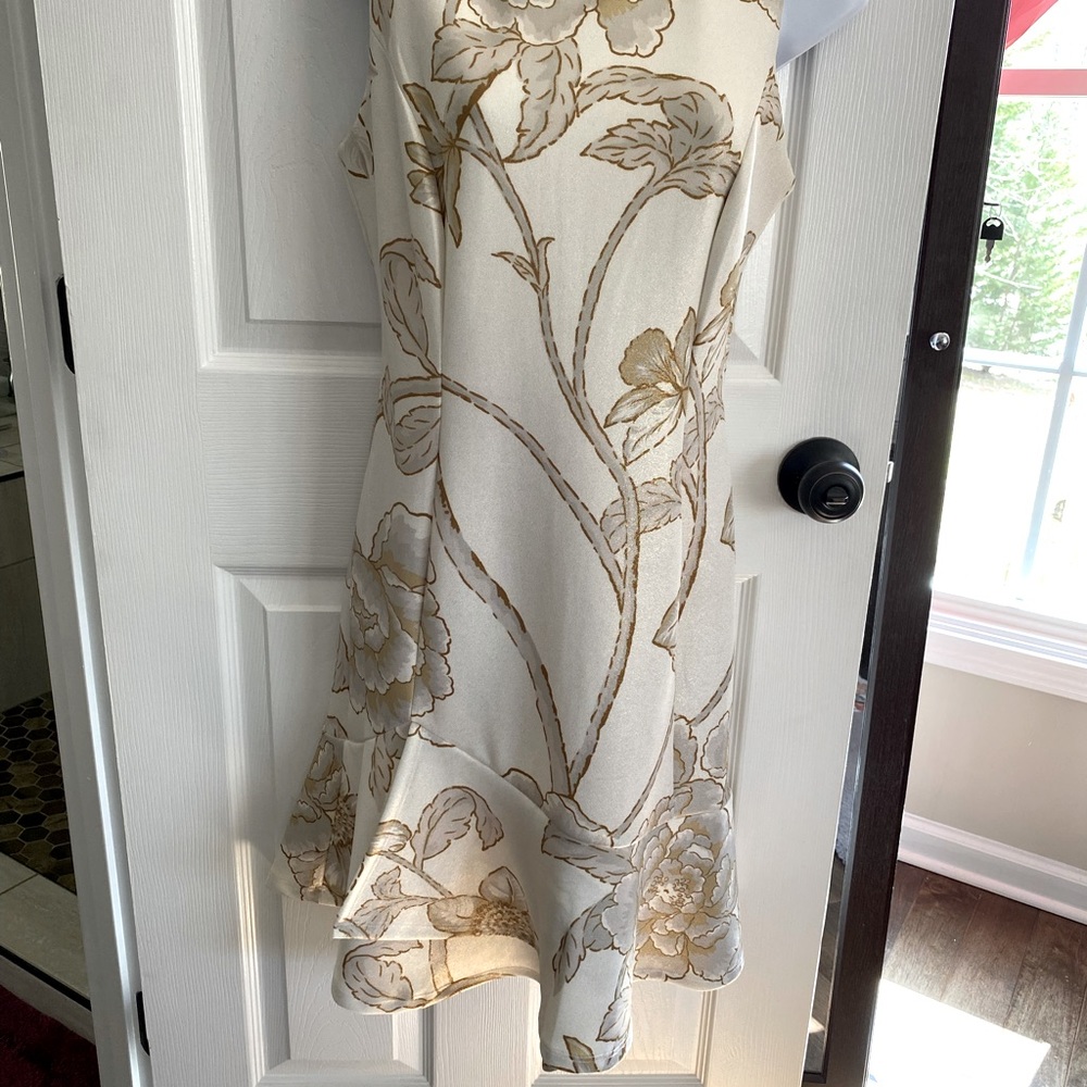 Beautiful sleeveless light patterned dress, below the knee with layered hemline.